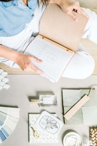 The image features a person holding an open box that reveals the logo of BIYNIUM with a floral and leaf design