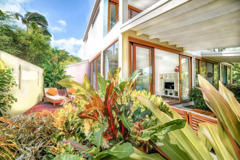 Luxurious home exterior with clear glass windows and tropical patio setting
