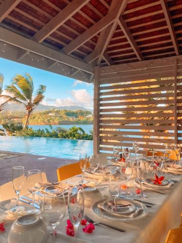 Elegant outdoor dining setup with pool and scenic view, perfect for fine dining.