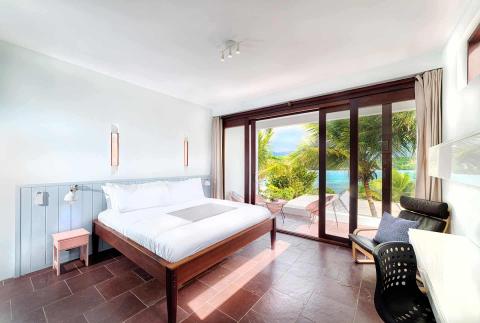 Modern bedroom with beach view, double bed, and cozy decor.