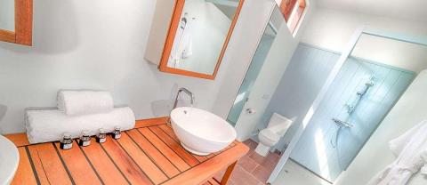 Modern bathroom with freestanding tub, shower, wooden accents and bright lighting