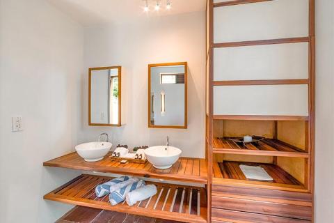 Modern bathroom with wooden countertop, vessel sinks, and neutral tones.