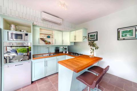 Modern mint green kitchen with stainless steel appliances and wooden island