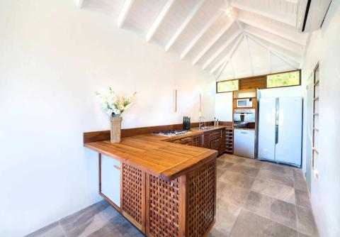Modern kitchen with high ceiling, wooden island, and natural light