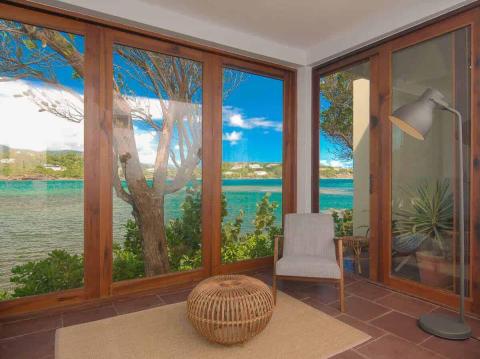 Modern indoor space with large windows overlooking a coastal landscape and stylish decor.