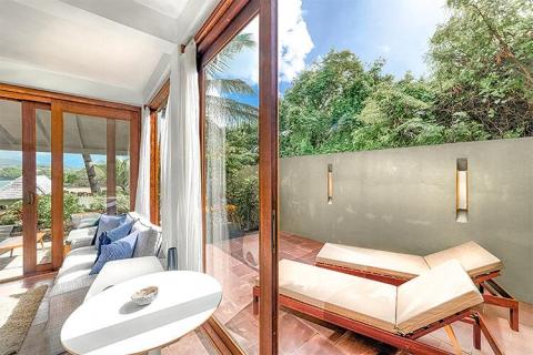 Indoor lounge and outdoor patio seamlessly blend in modern home.