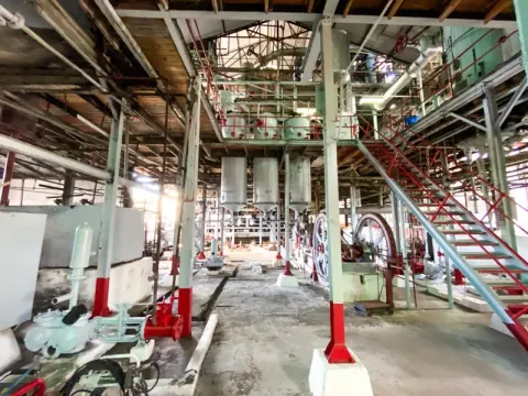 Industrial Facility Interior: Distillery or Factory with Extensive Machinery and Multi-Level Structure A Interior of an industrial facility with extensive machinery, gears, tanks, and red railings.