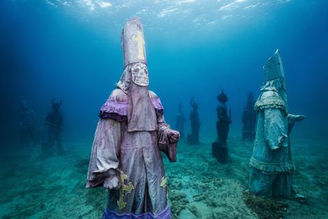 Underwater Sculpture Park: Historical Clerics in a Mystical Marine Setting Underwater scene with historical statues in ornate attire, creating a serene, mysterious mood.