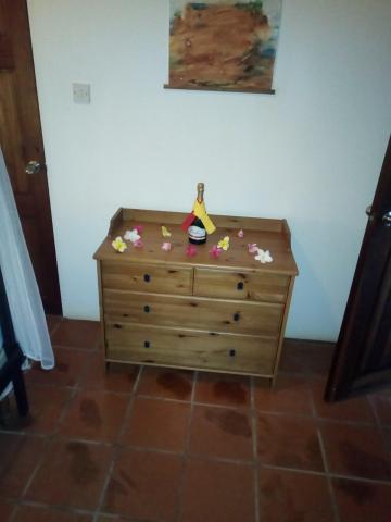 Dresser with wine bottle and festive decorations under abstract art