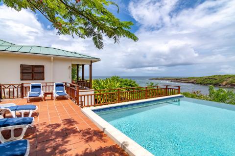 Luxurious coastal home with pool and ocean view, tropical setting.