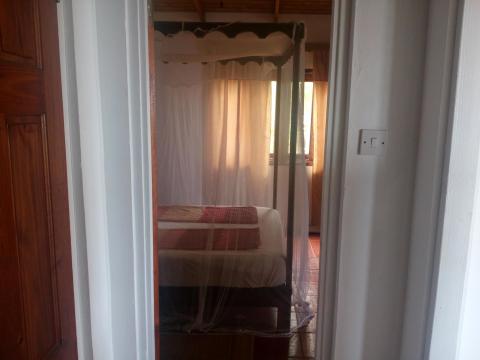 Traditional bedroom with wooden canopy bed and serene decor.