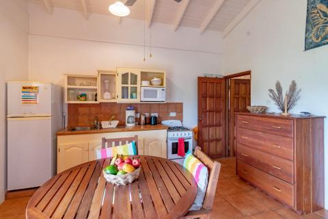 Cozy kitchen with wooden dining set, creamy cabinets, and rustic decor.