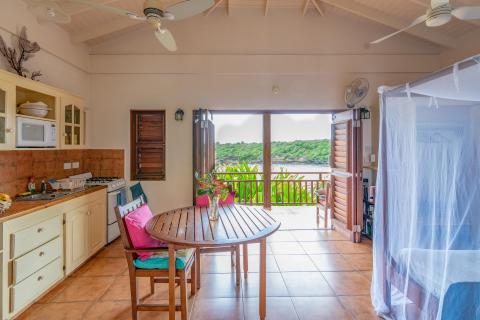 Cozy tropical holiday home interior with kitchen and deck views.