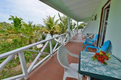 Scenic tropical balcony view with colorful chairs and sea backdrop