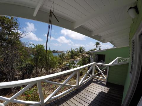 Scenic tropical balcony view with lush vegetation and serene blue sea.