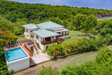 Luxurious seaside property with pool, tropical garden, and white house