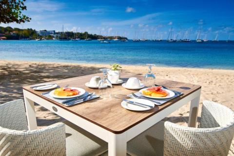 Seaside dining setup with fruit plates and sea view, perfect for a peaceful meal.