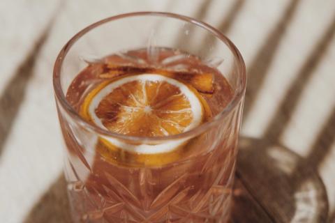 Cocktail with orange slice in a decorative glass, ideal for special occasions.
