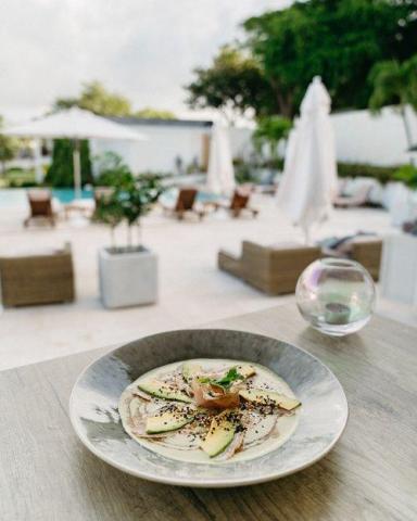 Gourmet appetizer at luxury resort with pool background and bubble effect.