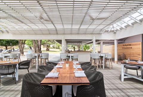 Outdoor dining at The Beach Club Calabash with modern furniture and scenic views.