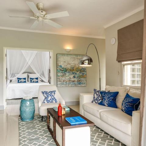 Coastal-themed room with blue and white decor, canopy bed, and sea-inspired artwork