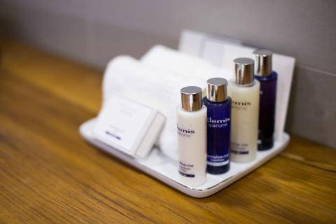 Elemis personal care products arranged on tray, including shampoo and bath gel.