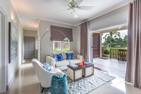 Stylish room with white sofa, blue pillows, and tropical view
