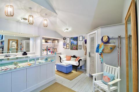 Stylish boutique interior with beach-themed decor and casual-chic items for sale.