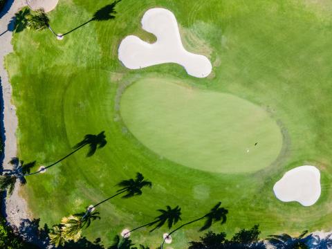 Cayman Tourism Board Mickey Mouse Bunker: A Unique Aerial View of a Tropical Golf Oasis This image shows an aerial view of a golf course