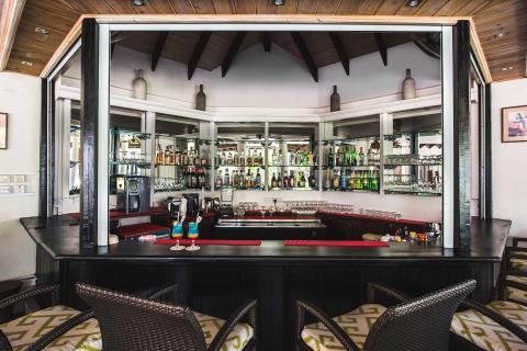 Stylish bar with wooden decor, well stocked shelves, and cozy seating.