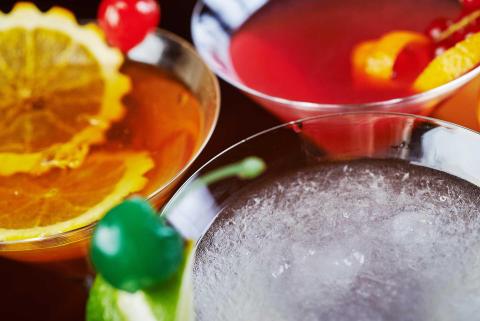 Trio of colorful cocktails with garnishes in classic glasses, ideal for a bar setting