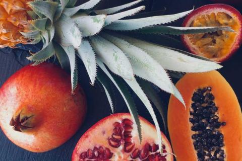 Assorted exotic fruits, including pomegranate, papaya, passion fruit, and pineapple.