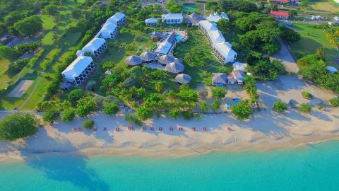Aerial view of a coastal resort with white buildings and a turquoise sea.