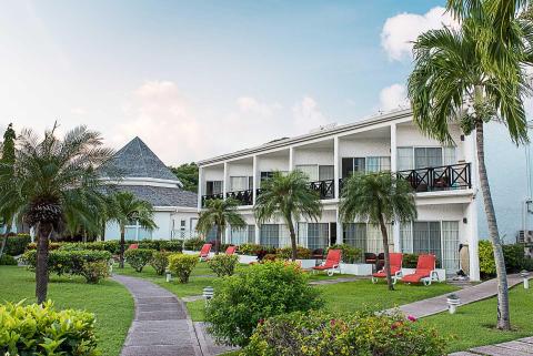 Luxurious tropical resort with lush gardens, balconies, and pyramid roofs
