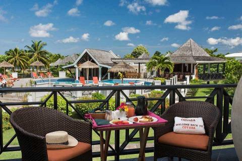 Coyaba resort breakfast on balcony overlooking tropical pool scene