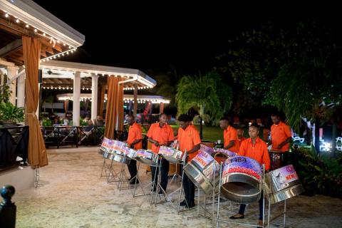 Caribbean musicians play steel drums at a tropical resort evening event
