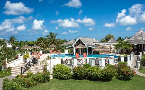 Luxurious tropical resort with pool, thatched gazebos, and palm trees