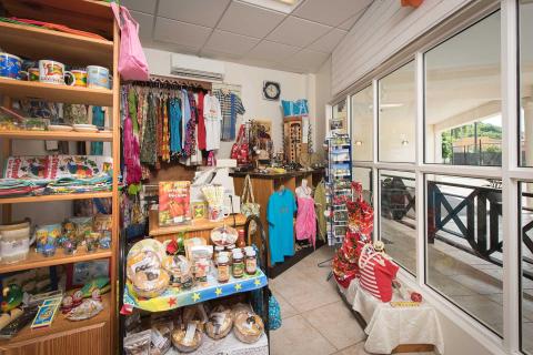Colorful souvenir shop interior with local crafts, clothes, and snacks on display.