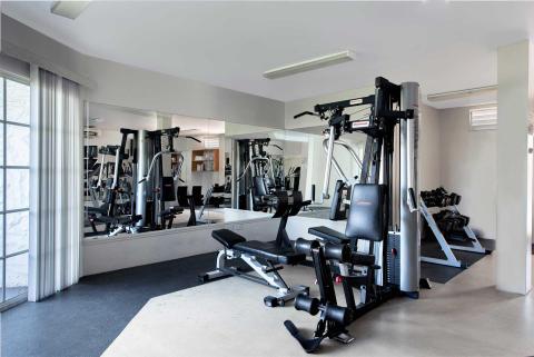 Modern gym with multi-gym systems, weight machines, and large mirror for workouts
