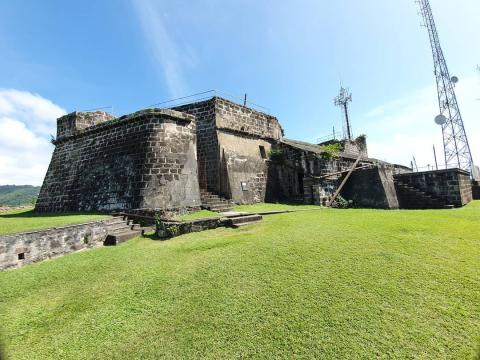 Old Fortress With Modern Towers - Historic Site Old fortress with stone walls, green lawns, modern tower, clear sky, historic and modern blend