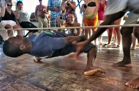 Man Expertly Performs Limbo Dance At Beach Event Man skillfully performing limbo dance at festive beach event with cheering crowd