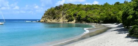 Serene Beachscape With Boats And Clear Blue Sea Serene beachscape with clear blue sea, sandy shore, and lush greenery ideal for relaxation