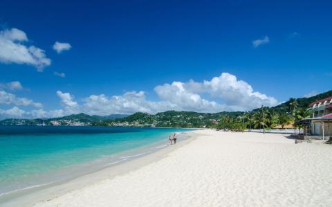 Stunning Tropical Beach With Pristine Sand And Clear Waters Tropical beach with white sand, turquoise water, lush hills, and palm trees, ideal for relaxation.