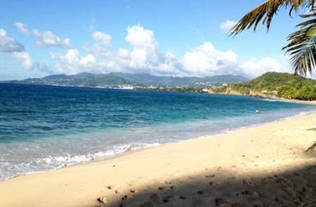 Scenic Tropical Beach With Blue Waters And Mountains Scenic tropical beach with blue waters, sandy shore, and lush mountains under sunny skies.