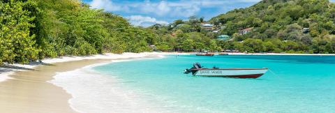 Tropical Beach With Boat And Colorful Houses Tropical beach with white sand, clear turquoise water, and a boat named