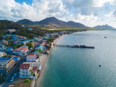 Scenic Coastal Town With Pier And Boats Aerial View Aerial view of a colorful coastal town with a pier and boats by the sea