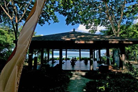 Beachfront Yoga Session In Serene Pavilion Outdoor yoga class in a pavilion by the beach with serene sea views