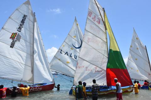 Sailboat Race Preparation On Sunny Beach Day Sailboats with colorful sails prepare for race in sunny coastal area