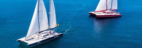 Two Sailboats In Calm Blue Sea, Modern And Colorful Two sailboats calmly sailing, one modern in white, other red and white, on a serene blue sea.