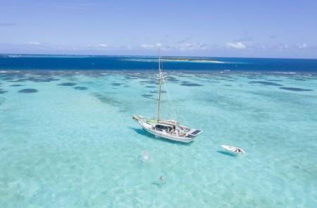 Sailboat In Turquoise Waters With Coral View Serene seascape with sailboat in turquoise waters, coral visible, ideal for sailing.